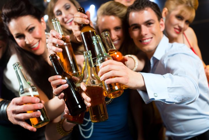 young-people-in-club-or-bar-drinking-beer-out-of-a-beer-bottle-and-have-fun