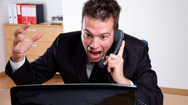 Man-Angry-at-Computer-on-Phone-in-Office