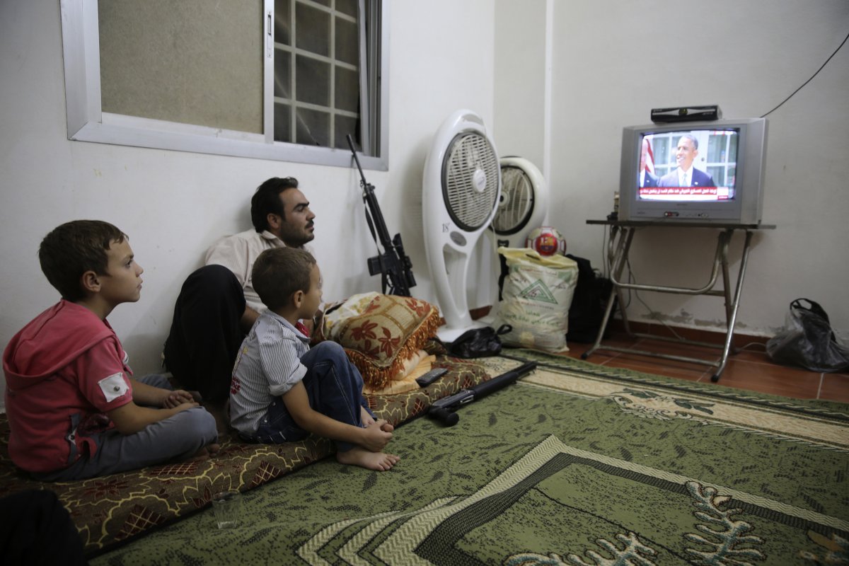 a-free-syrian-army-fighter-watches-a-speech-by-barack-obama-from-ghouta-syria