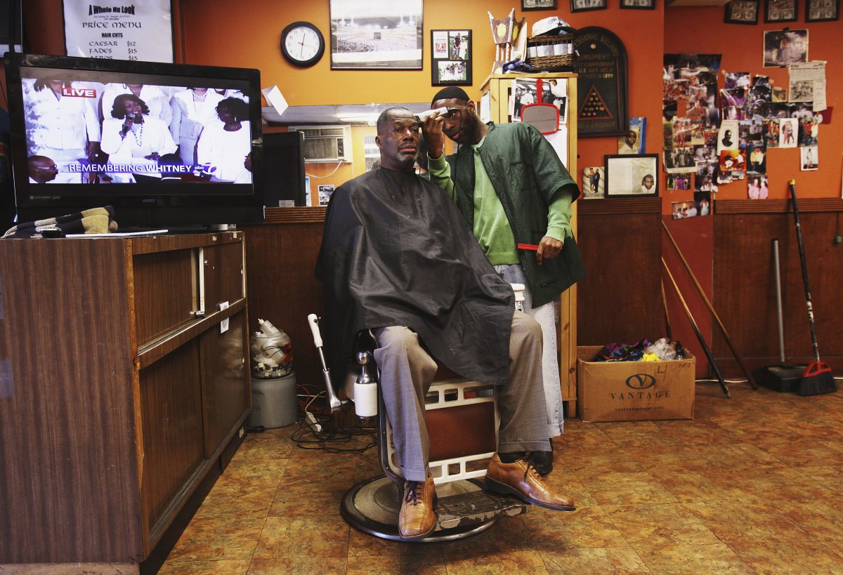 a-man-gets-his-haircut-in-newark-new-jersey-while-the-tv-plays-in-the-background