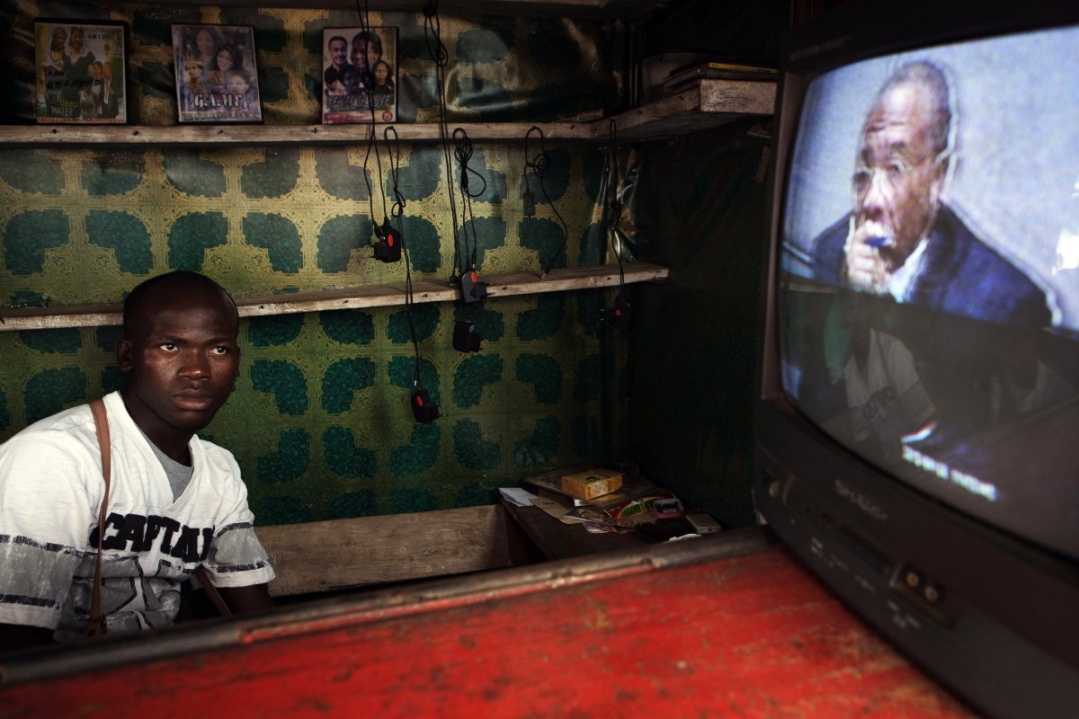 a-street-vendor-watches-a-live-broadcast-as-the-now-former-liberian-president-charles-taylor-is-convicted-of-aiding-and-abetting-war-crimes-in-2012