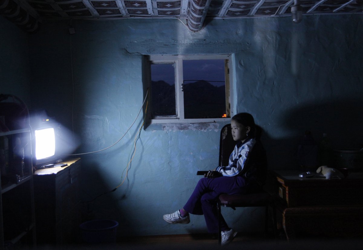 a-young-girl-watches-tv-in-a-house-at-a-tourist-campsite-in-the-bulgan-province-of-mongolia