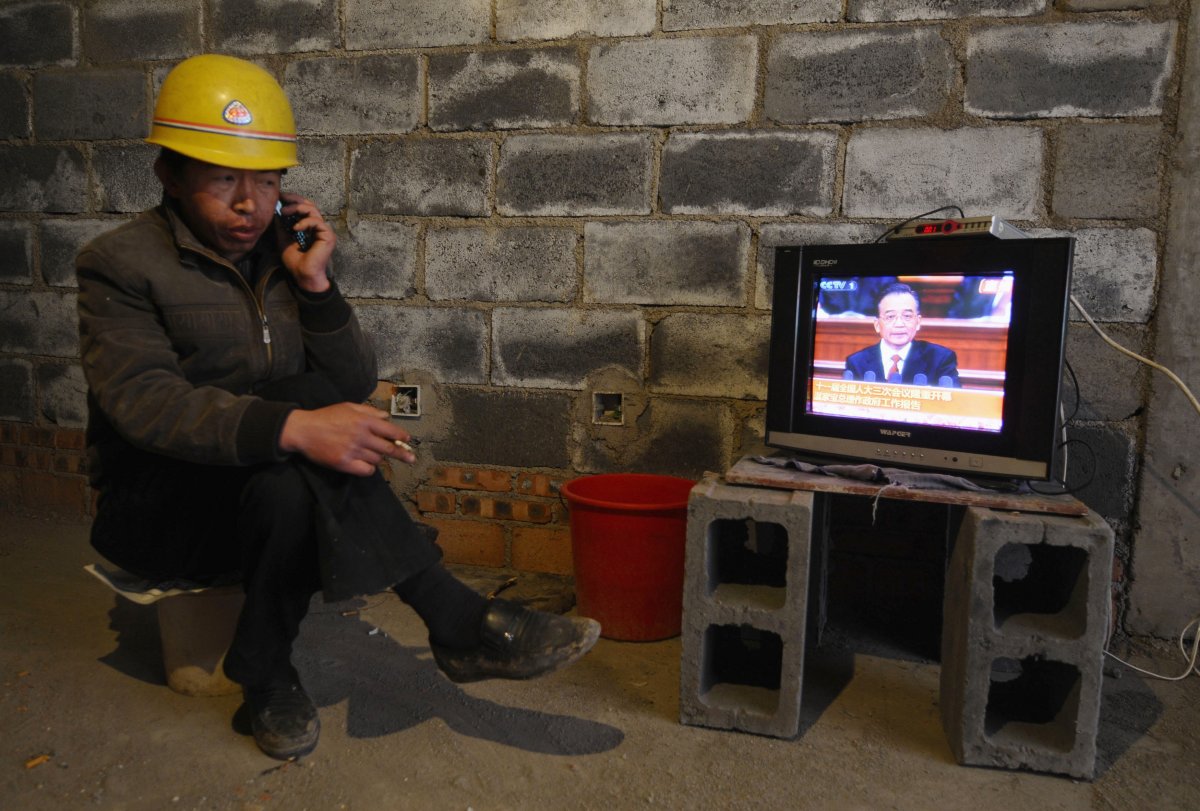 simultaneously-talking-on-the-phone-and-smoking-a-cigarette-a-labor-worker-in-changzhi-china-catches-a-government-broadcast-on-tv