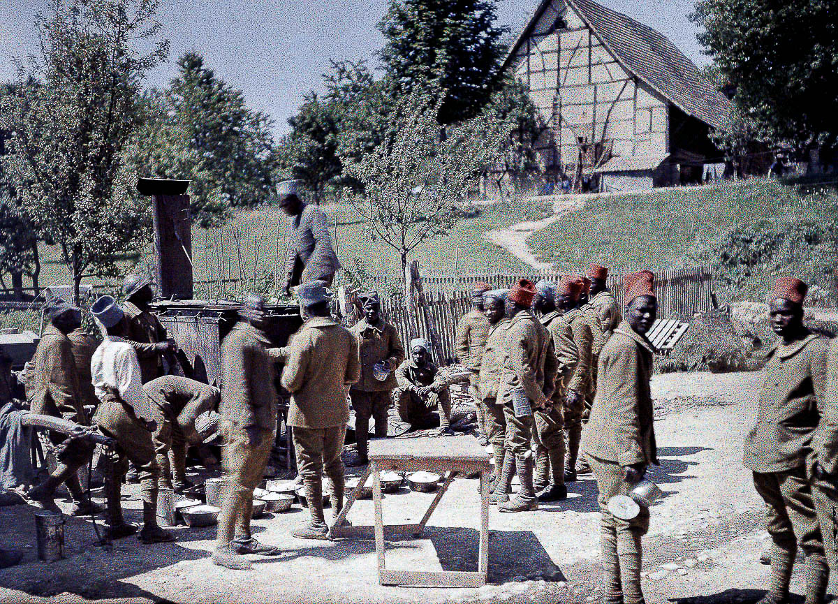 A group of Senegalese soldiers serving in the French Army as infantrymen is having lunch in Saint-Ulrich, Department Haut-Rhin, Region Alsace. 16th June 1917. Western Front. World War I. Autochrome LumiËre. Photo: Paul Castelnau (1880-1944). France. (Photo by Galerie Bilderwelt/Getty Images)