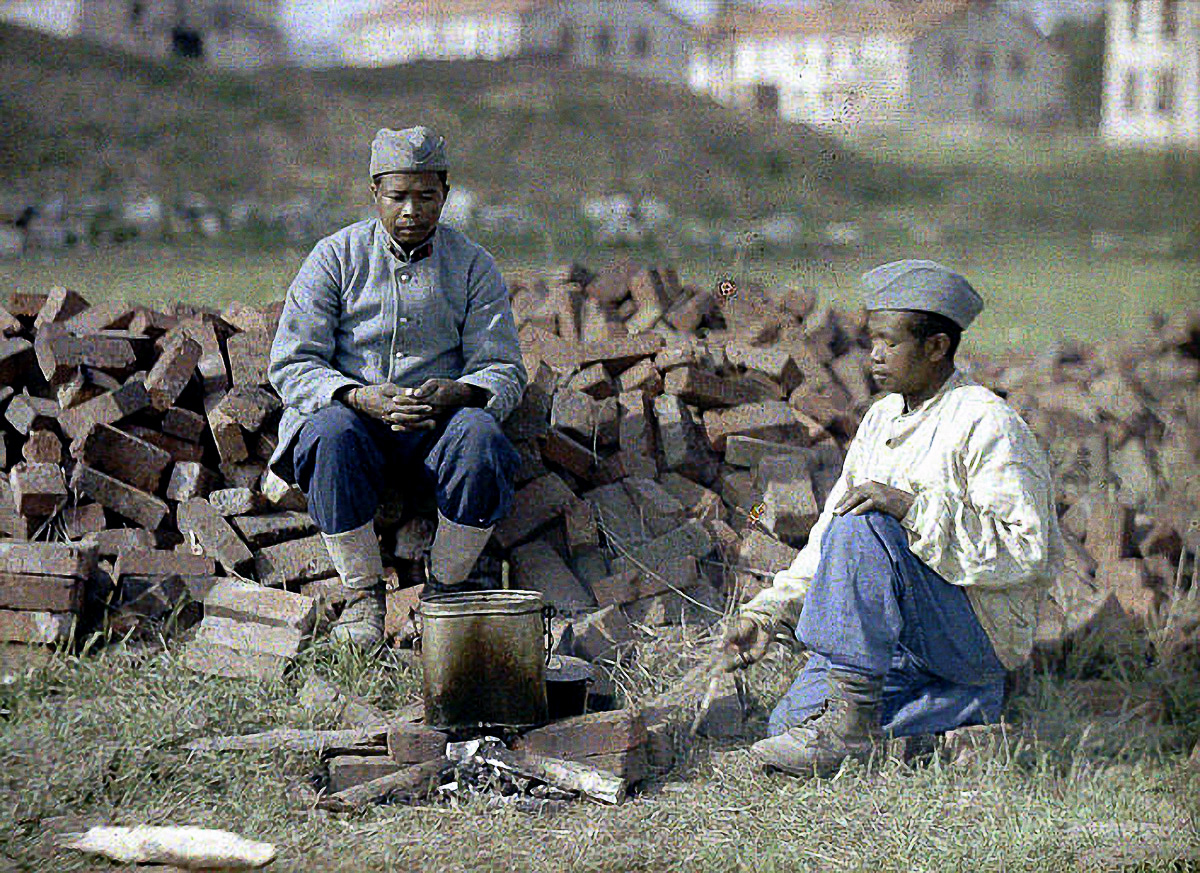 Two French soldiers from Africa are heating up a meal on an outdoor fireplace made from brick. World War I, Western Front. 1917. Color photo (Autochrome LumiËre) by Fernand Cuville (1887-1927). Soissons, Aisne, France. (Photo by Galerie Bilderwelt/Getty Images)