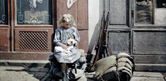 Момиче с кукла. До него са две пушки и раница на войници от Западния фронт.