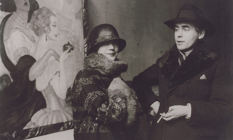 Герда и Ейнар позират пред картина на художничката.