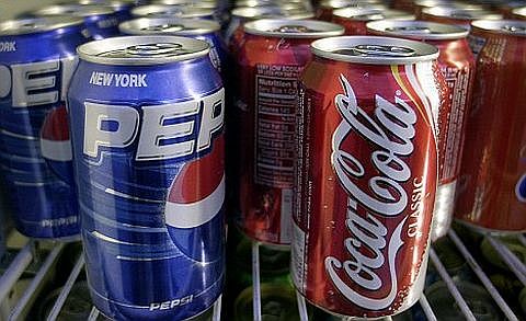 ** FILE ** Cans of Pepsi and Coke are shown in a news stand refrigerator display rack in a New York file photo from April 22, 2005. Coca-Cola and Pepsi are usually bitter enemies, but when PepsiCo Inc. got a letter offering to sell Coke trade secrets, it went straight to its corporate rival. (AP Photo/Mark Lennihan, File)